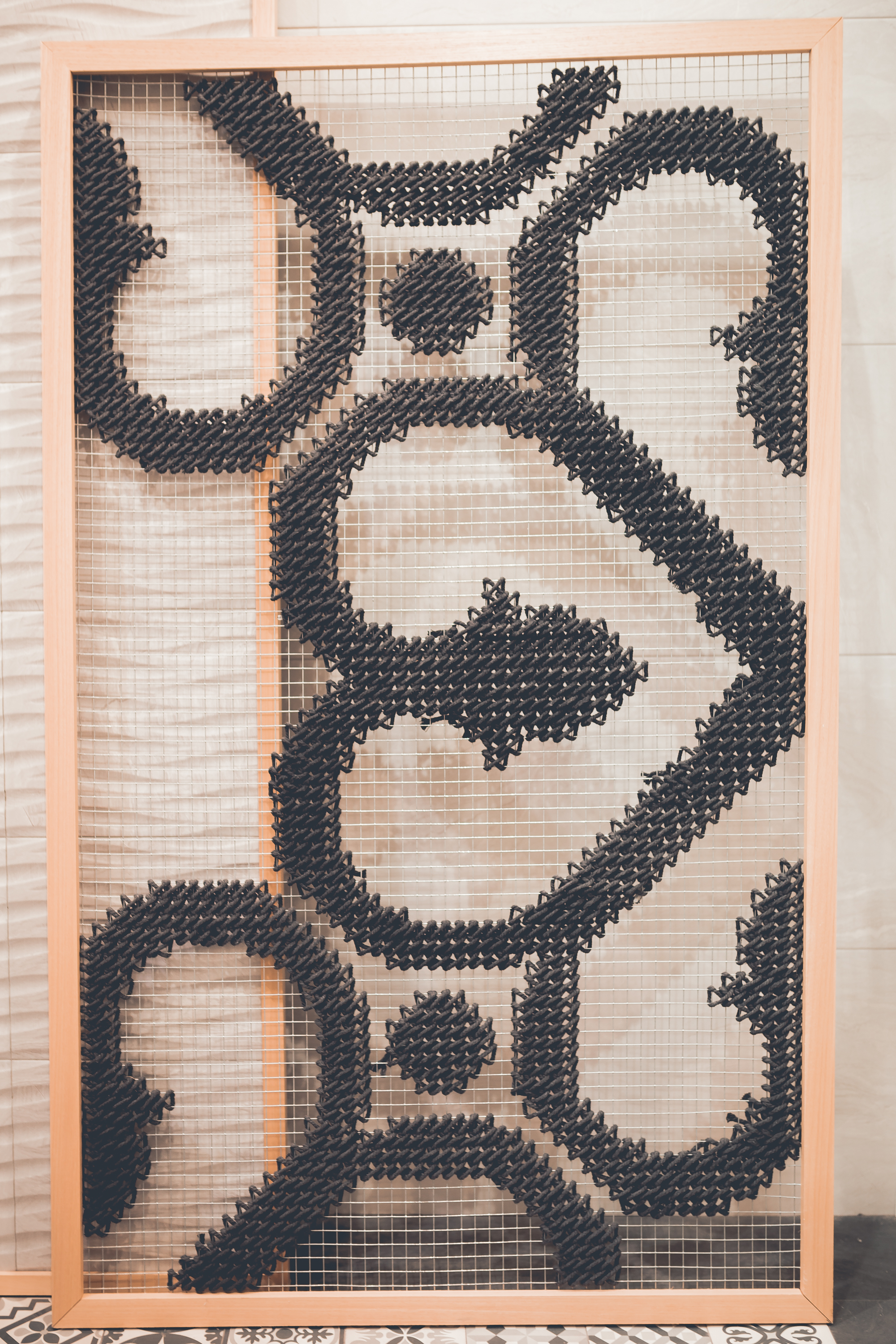 Gayafores — embroidered black geometric tile pattern panel in wood frame