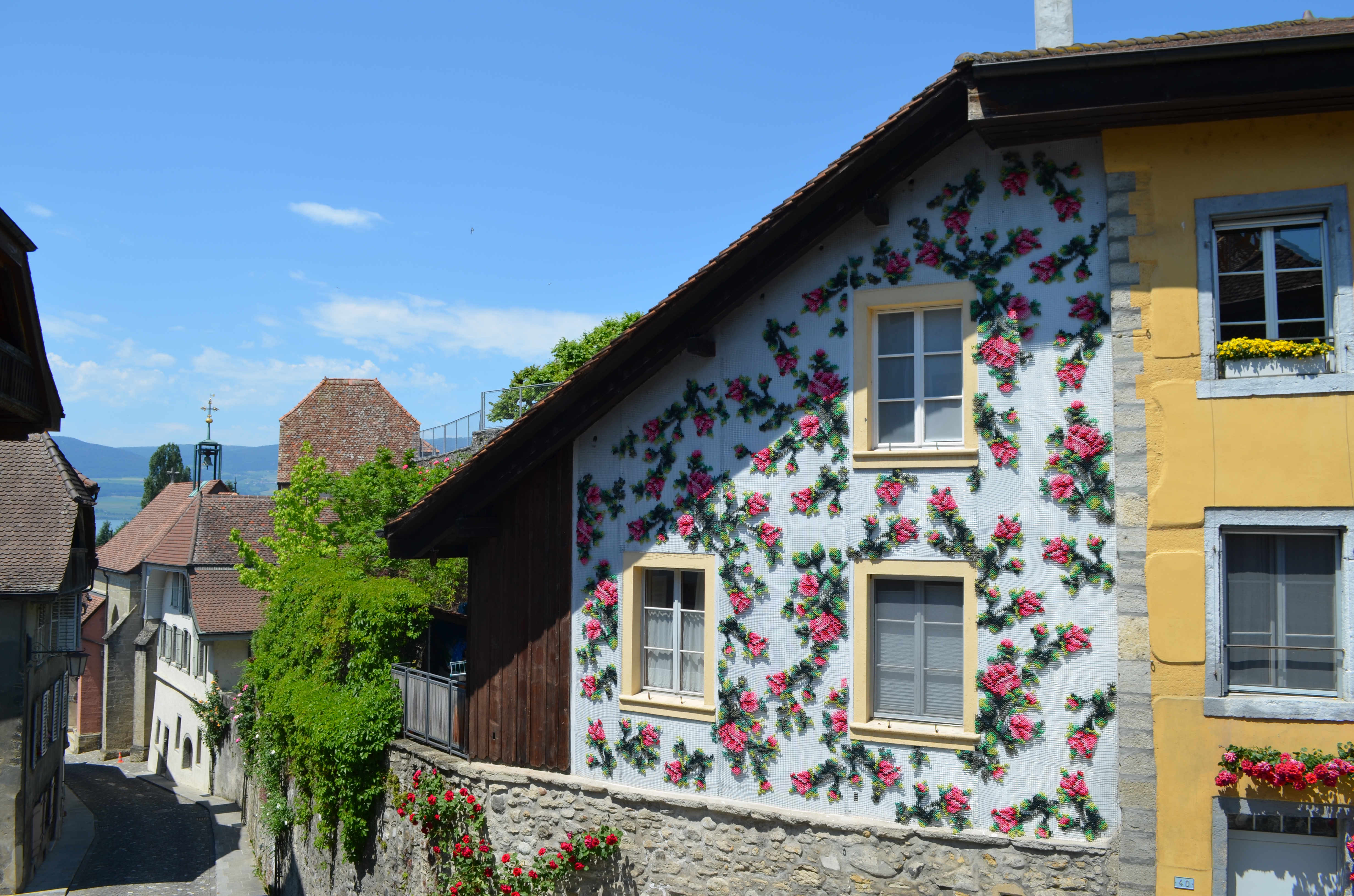 Flores — embroidered rose facade intervention Estavayer-le-Lac Switzerland