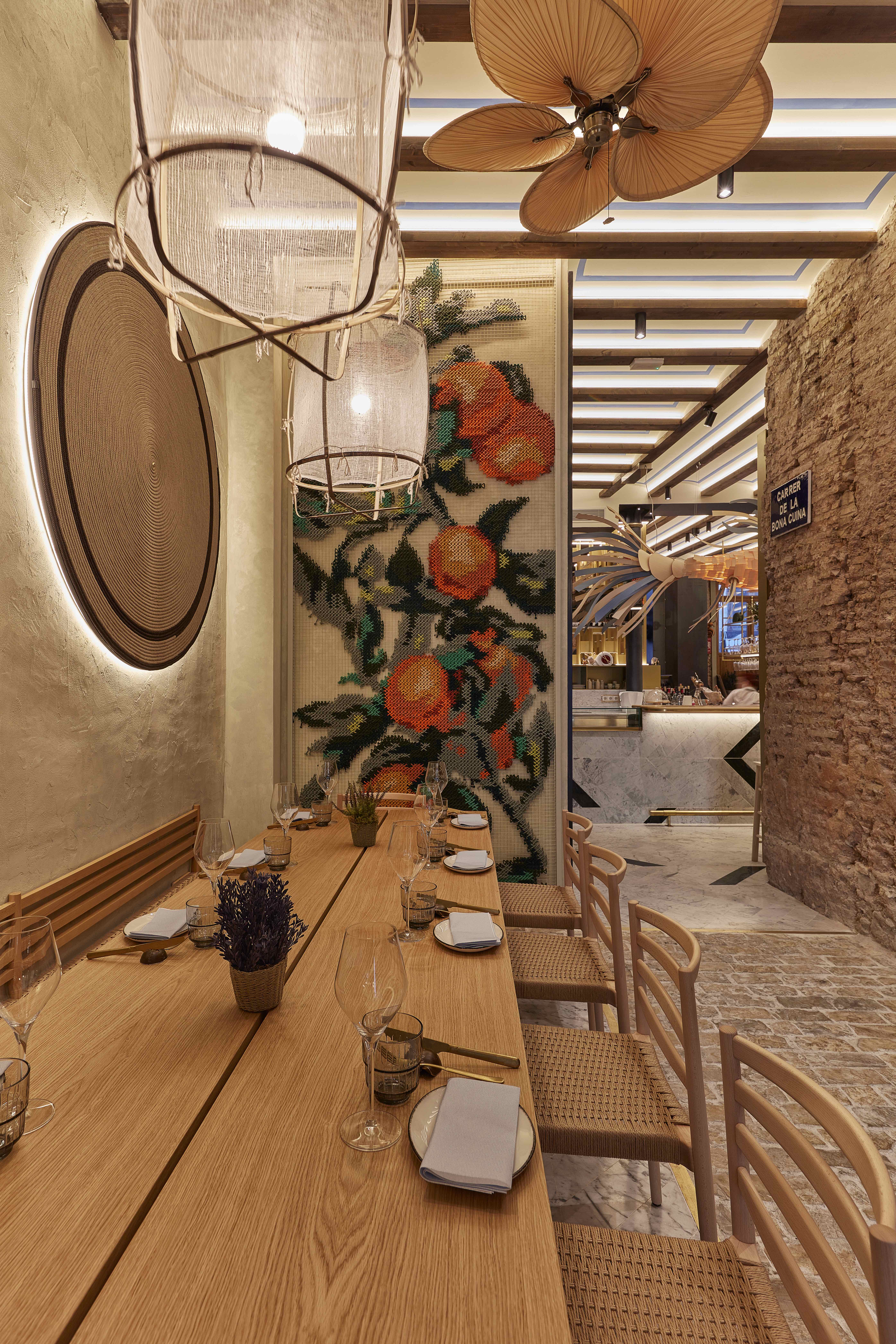 Vaqueta — embroidered orange tree panel at restaurant entrance